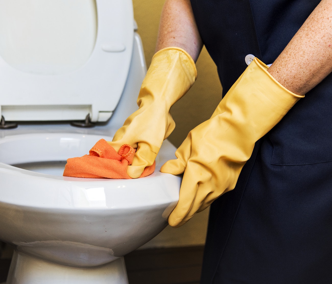 Housekeeper cleaning a toilet