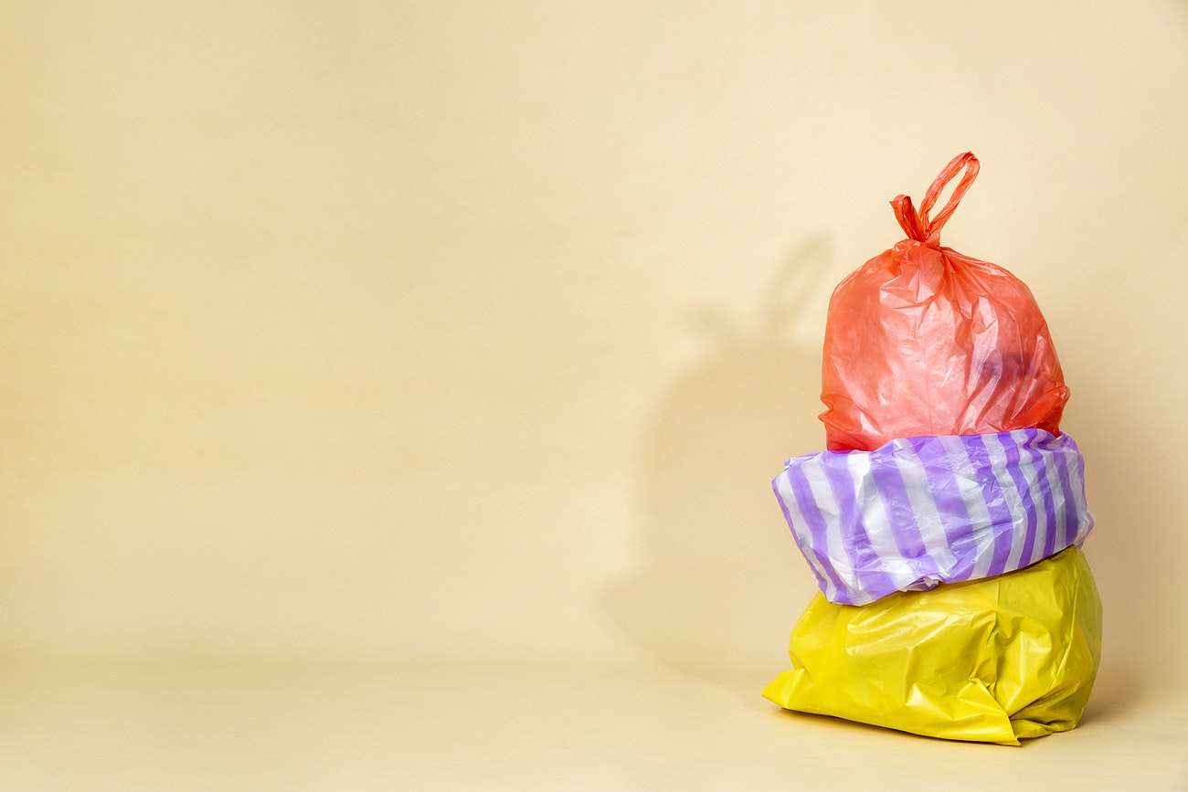 Colorful garbage bags isolated on yellow background